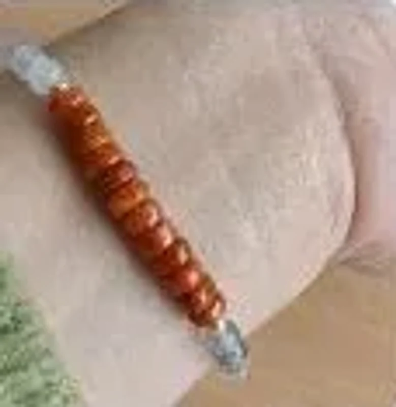 Ảnh khách gửi: cận cảnh vòng hạt đỏ cam trên cổ tay